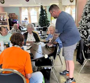 Brother Anthony Fisher serves a warm Mothers Day meal to a senior citizen on May 16, 2023 at the Warren County Senior Center