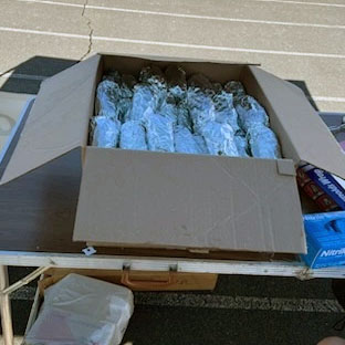 A box full of freshly grilled hot dogs cooked and wrapped by Masons stands ready at the All Children Matter Jubilee on April 15, 2023