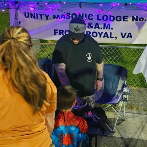 Anthony Fisher grabs candy to hand out to a child dressed as his hero, Spider Man, at the Warren County Department of Social Services Jack-O-Lantern Jubilee on October 26, 2023