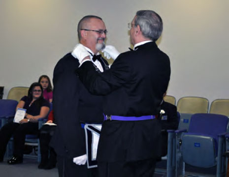 Marshal Davidson places the Master's jewel on Dennis Haas.