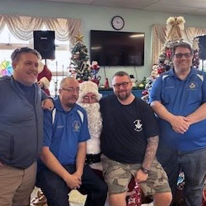 Sheriff Mark Butler, WM Will Bryan, Santa Clause (Terry Fritts), Anthony Fisher, and Lewis Moten pose for a photo with Santa Clause at the Warren County Senior Center on December 20, 2023