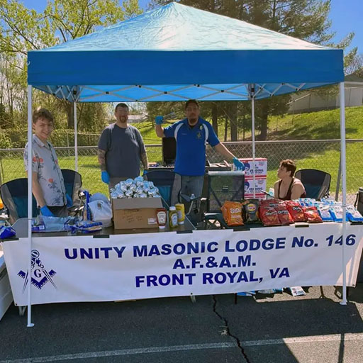 Will and Anthony offer hot dogs and chips in the Masonic booth at the All Children Matter Jubilee on April 15, 2023