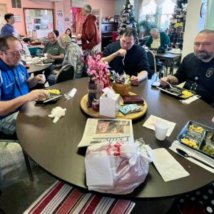 WM Will Bryan, Jacob Witzen, and Terry Fritts sit with seniors to enjoy a warm meal at the Warren County Senior Center on February 14, 2023