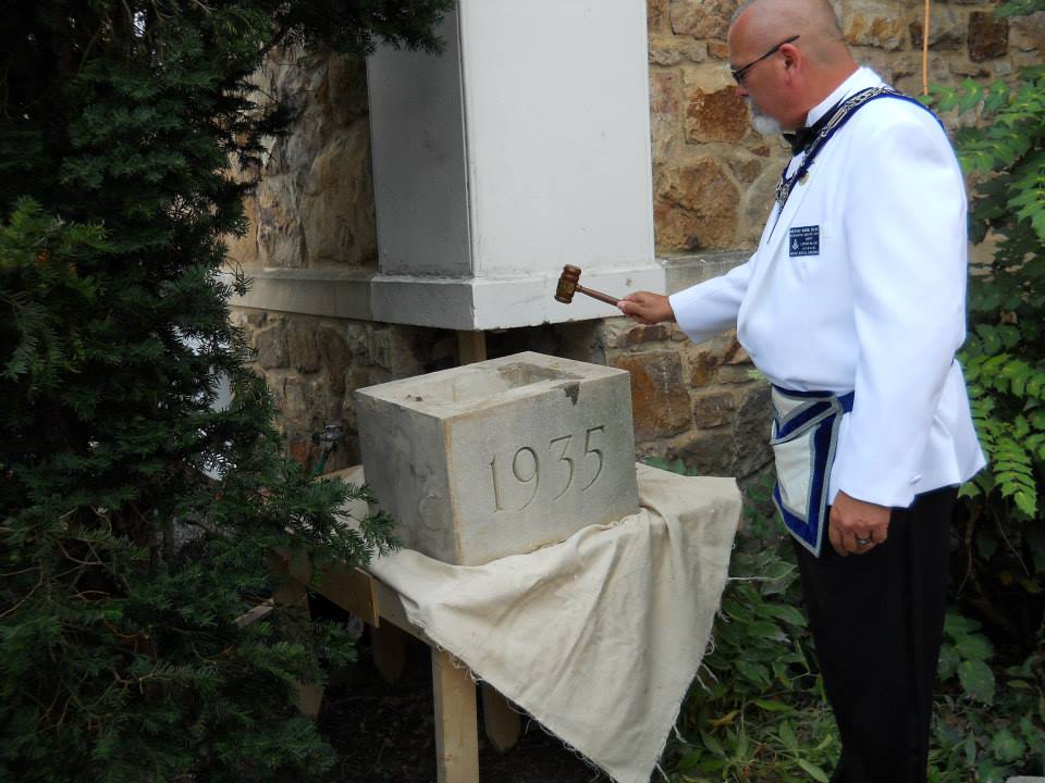 Worshipful Master Dennis Haas rapts his gavel on the cornerstone.