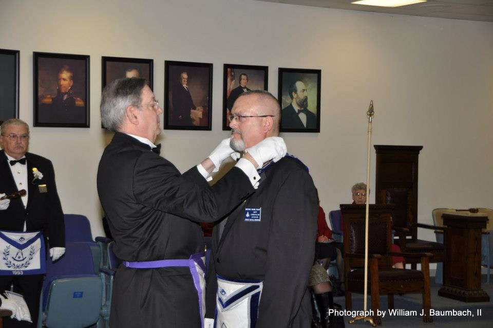 Brother Kevin presents Worshipful Dennis Haas with the jewels of his office.