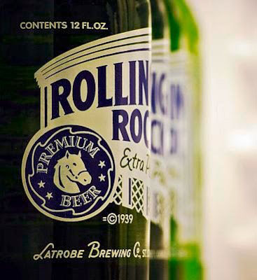 Close-up of green Rolling Rock beer bottles lined up behind each other