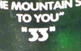 Close up view of the number 33 on the back of a green Rolling Rock beer bottle