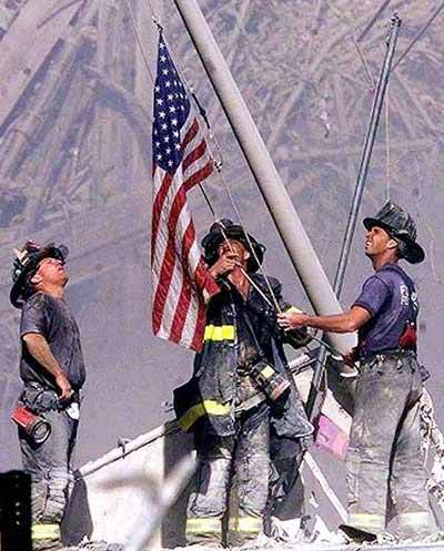 Three Firemen raise an American flag at the New York City World Trade Center.