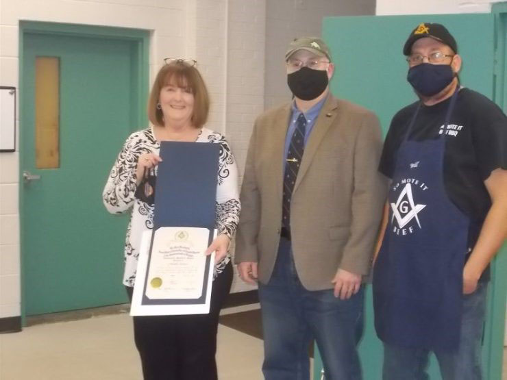 Michelle Smelter displays her Community Builders Award from the Grand Lodge of Virginia along with Brother Charles Taggart and Brother Will Bryan on March 4, 2021 at the Front Royal Thermal Shelter.