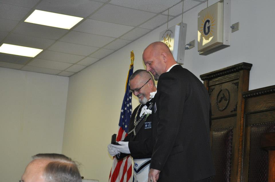 Worshipful Scott Cabazolo presents Dennis Haas with a gift.